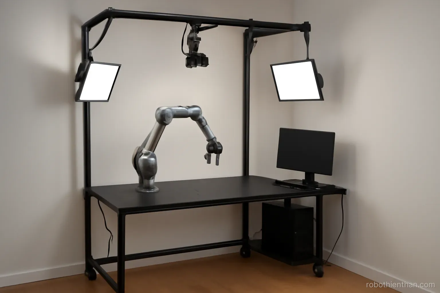 Bàn thí nghiệm robot gọn gàng với cánh tay, camera và máy tính trong phòng nhỏ
